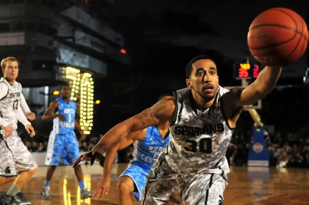 Free Intense basketball game with athletes in action on an outdoor court during nighttime. Stock Photo